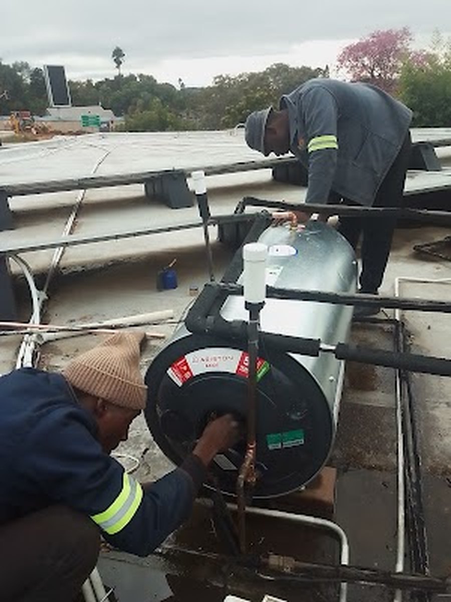 Plumbers installing a new geyser on a roof in Garsfontein